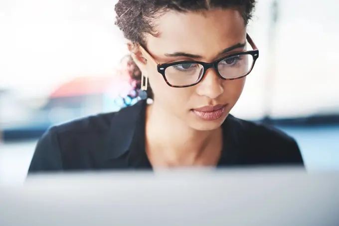 Great things happen when hard work and dedication merge together. a young businesswoman working on a computer in an office.