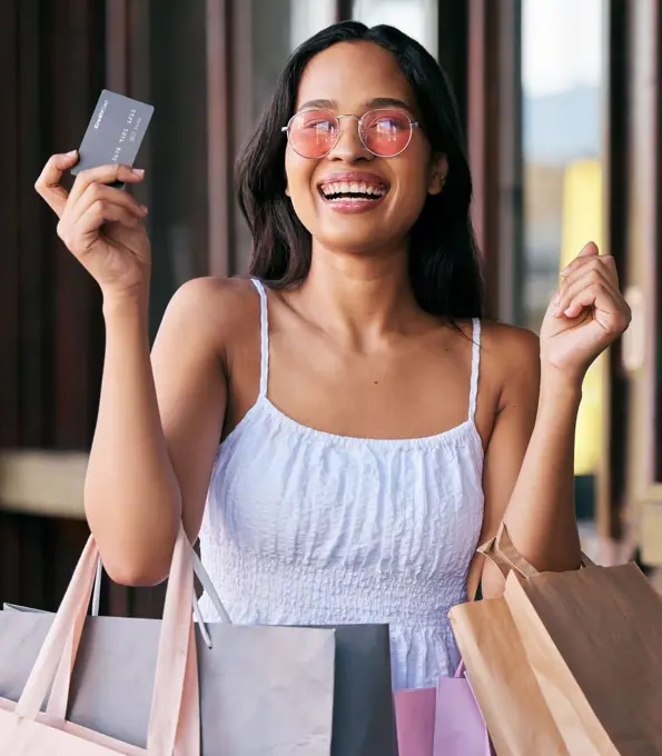 Woman, credit card and smile for shopping with bags in happy marketing, ecommerce or buying at the mall. Portrait of female shopper smiling with bank card for luxury, payment or purchase for clothing