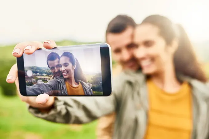 Their selfies are always on fleek. a loving couple taking a selfie outdoors.