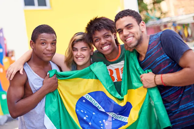 Proud of their nation. Portrait of a group of teenagers holding up the Brazilian flag.