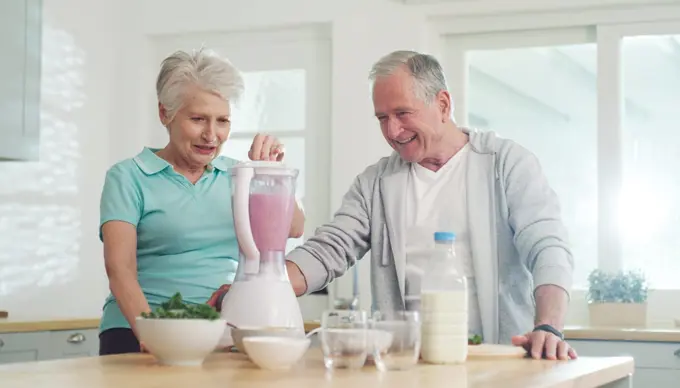 Lets start the day with a healthy smoothie. a senior couple making a healthy smoothie together at home.