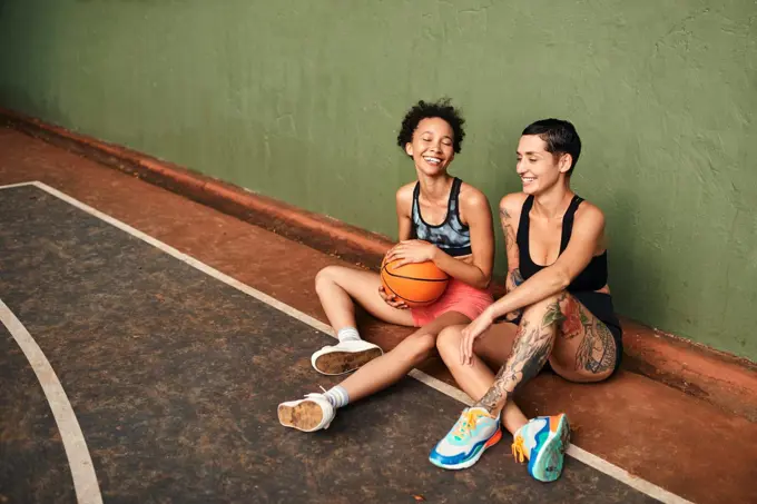 We always laugh when were together. a diverse group of sportswomen bonding after a basketball game together during the day.