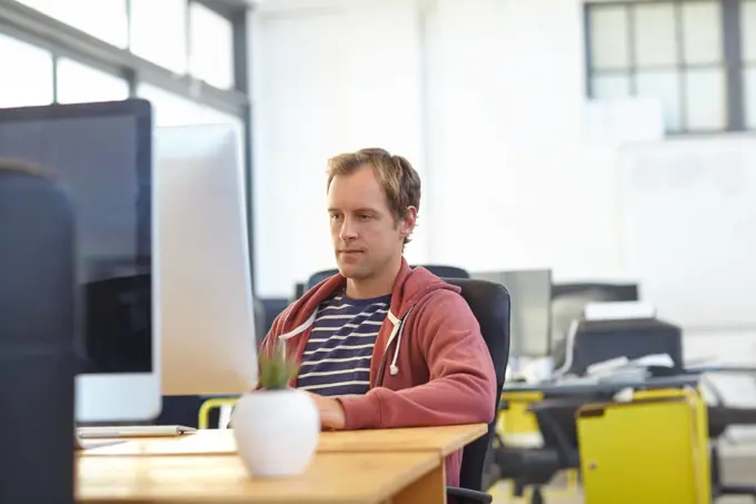 Working away. a designer at work on a computer in an office.