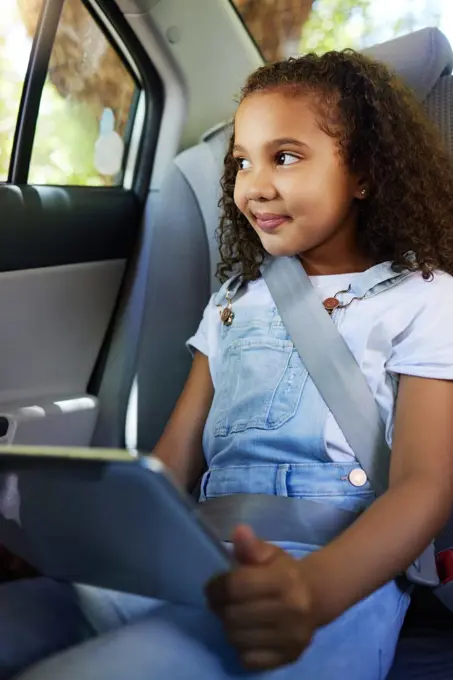 Child in car, smile and tablet on road trip with seatbelt for safety and device to watch educational video or online game. Technology, internet and travel, happy girl on backseat for drive or carpool