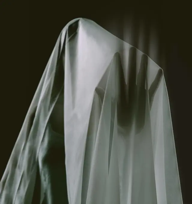 Touching the supernatural. A ghostly apparition of a woman isolated on a black background.