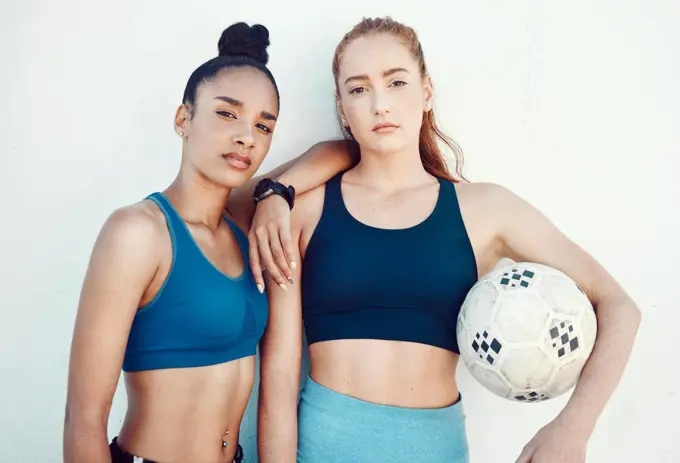 Soccer, women and portrait of friends with a ball standing by a white background for training. Fitness, football and girl athletes ready for a sports workout or exercise for a game together.