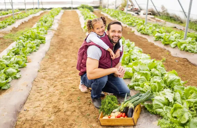 Child, father or farmer farming vegetables in a natural garden or agriculture environment for a healthy diet. Smile, dad and happy girl love gardening and planting organic food for sustainability