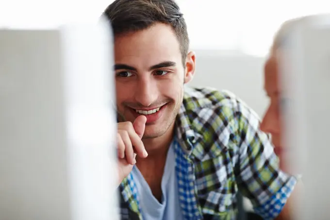 Hes happy with her work. Two colleagues working on a computer together.