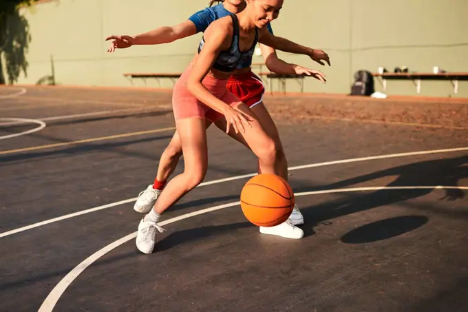 Shes putting me under pressure. an attractive young sportswoman blocking her opponent during a basketball game during the day.