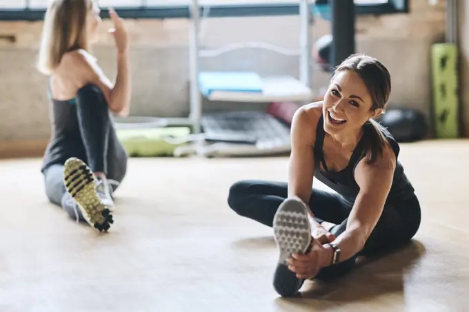 Portrait, stretching and women training, balance and workout for stress relief, wellness and healthy lifestyle. Face, female people and athletes on the floor, stretch legs and practice with progress