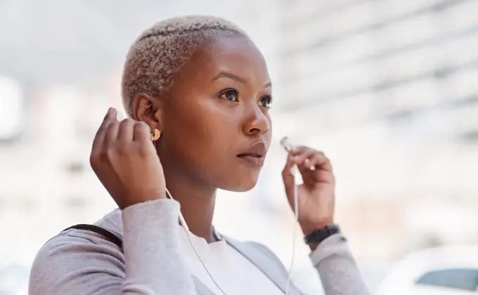 Music, thinking and vision with a business black woman in the city on her morning commute into work. Mindset, future and earphones with a young female employee streaming audio in an urban town