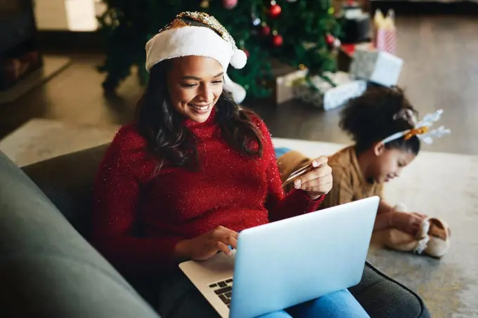 Christmas online shopping, e commerce and woman with credit card and laptop for internet and payment online. Holiday retail sale, family and ecommerce with mother buying and child playing on floor.