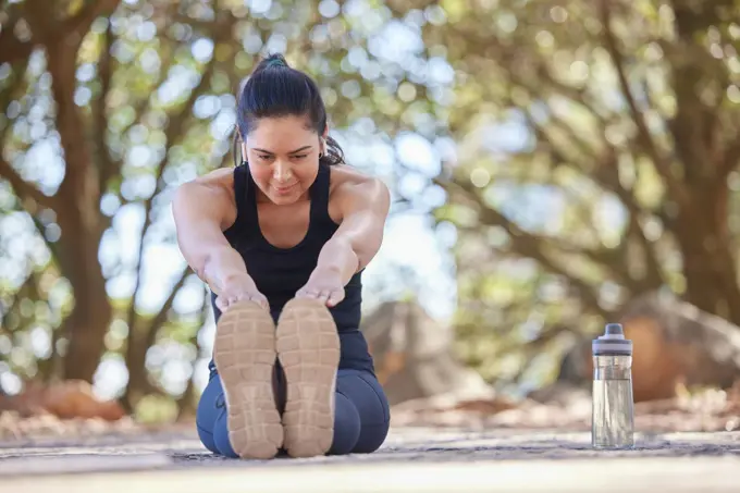 Woman, fitness and stretching leg, exercise and training outdoor for health, wellness and healthy lifestyle on floor. Stretch, workout and healthy person exercising legs on ground for body warm up