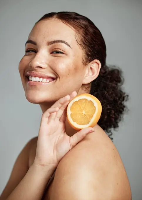 Woman, studio portrait and orange for skincare, health and wellness with cosmetic glow, self care and backdrop. Model, black woman and fruit for cosmetics, diet and healthy natural skin by background