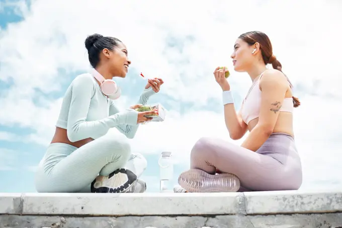 Salad, apple and fitness friends eating food outdoor for wellness, diet and vegan lifestyle with blue sky clouds mock up. Women or people with green fruits and vegetables lunch after an exercise