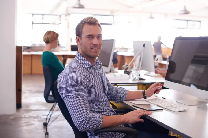 Hard at work. a handsome young man working in his office.