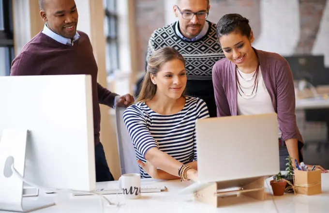 Producing impressive work as a team. a group of designers working together at a computer.