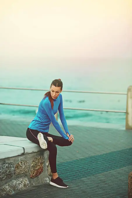 I choose to be healthy. Shot of a sporty young woman stretching before her run.