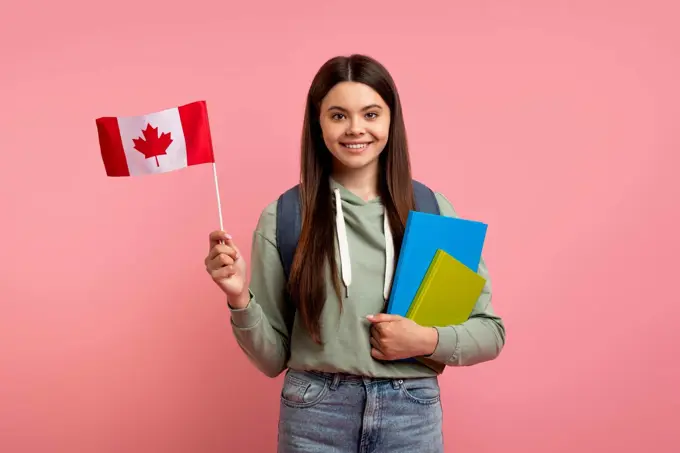 Study Abroad. Beautiful Teen Girl Holding Flag Of Canada And Workbooks