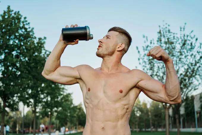 sports muscular man in the park healthy food fitness