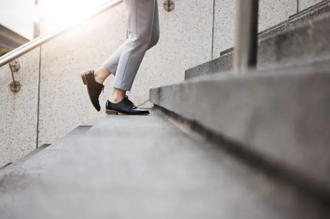 Stairs, morning person and legs walk, travel or on urban journey, outdoor commute or trip to work, destination or job. Town steps, arrival and closeup shoes, feet or agent climbing building staircase