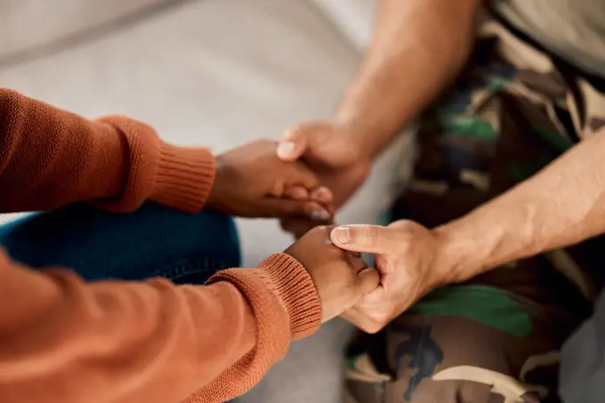 Soldier in counselling, man and woman holding hands in marriage, comfort and home coming. Support, trust and empathy, veteran in therapy with partner, helping hand and love in army mental health.