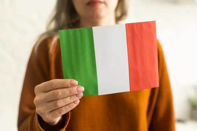 Person holding a Italian flag on a white background