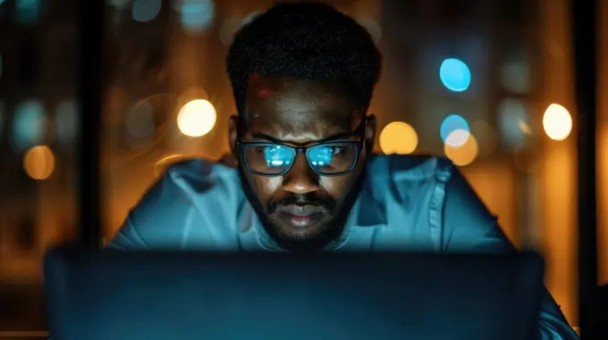 Stressed Business Professional in Tense Office Scene with Dramatic Lighting and Blurred Background..