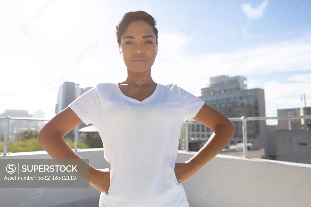 Strong woman standing for breast cancer awareness against a city background