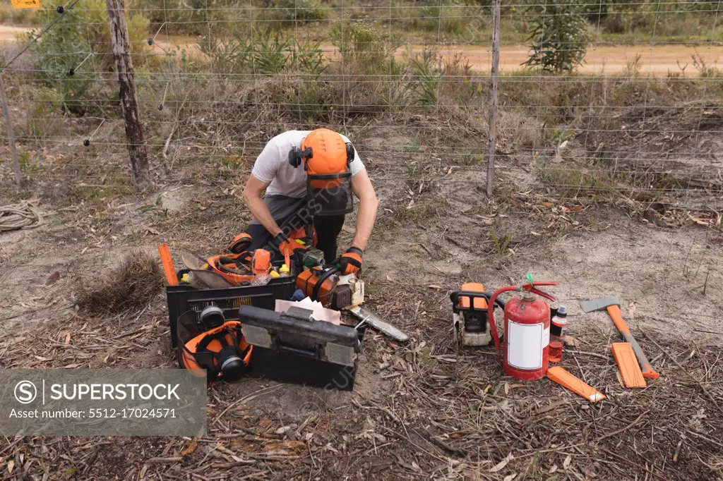 Lumberjack using chainsaw machine in the forest