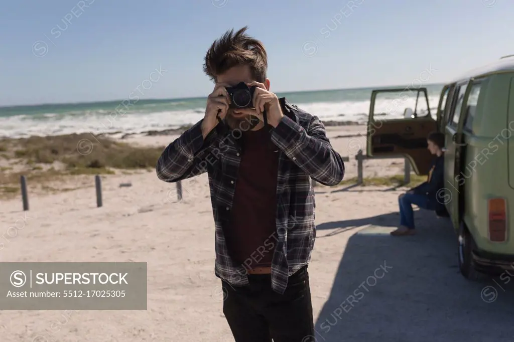 Man taking photo near beach on roadtrip