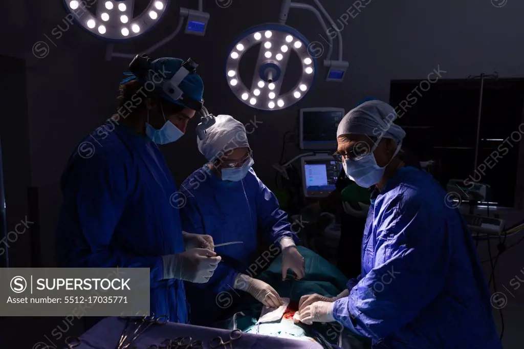 Front view of surgeons performing operation in operating room at hospital