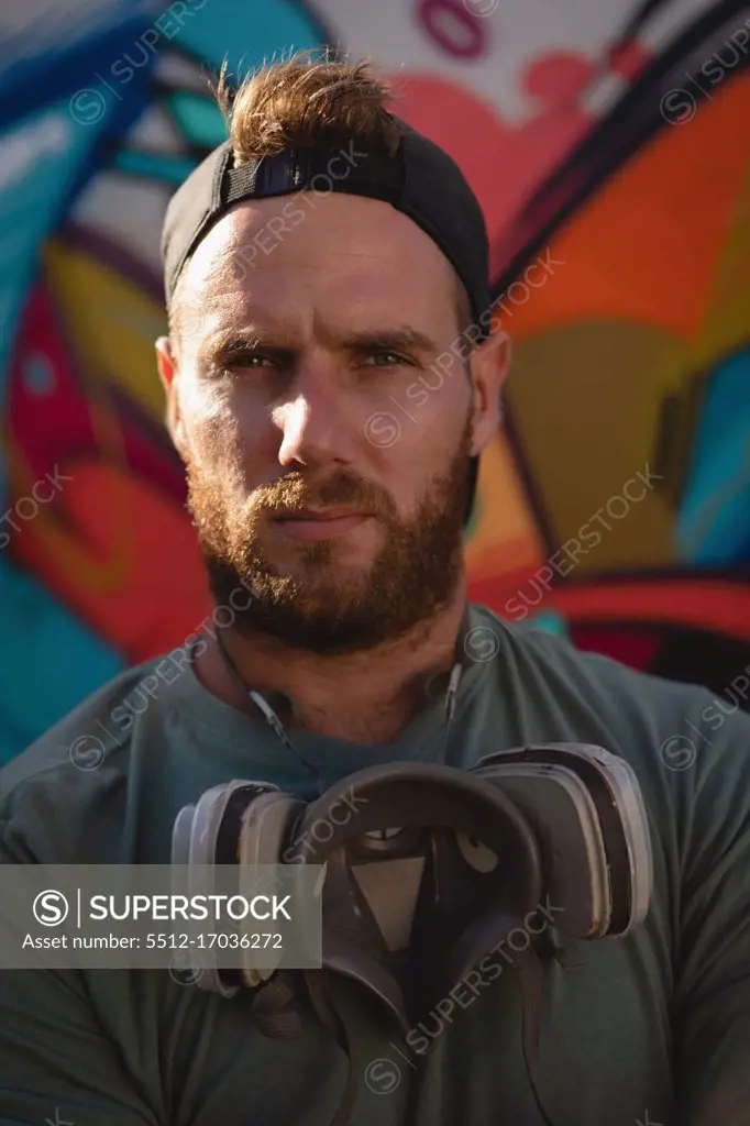 Portrait of graffiti artist standing with protective mask 