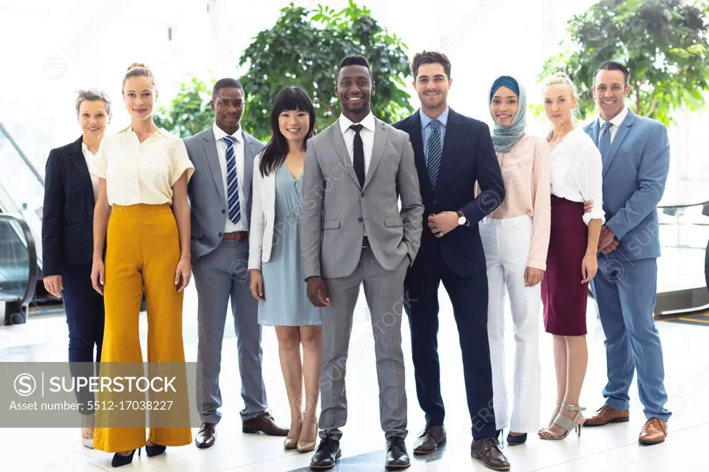 Front view of diverse executives all looking to camera in hall