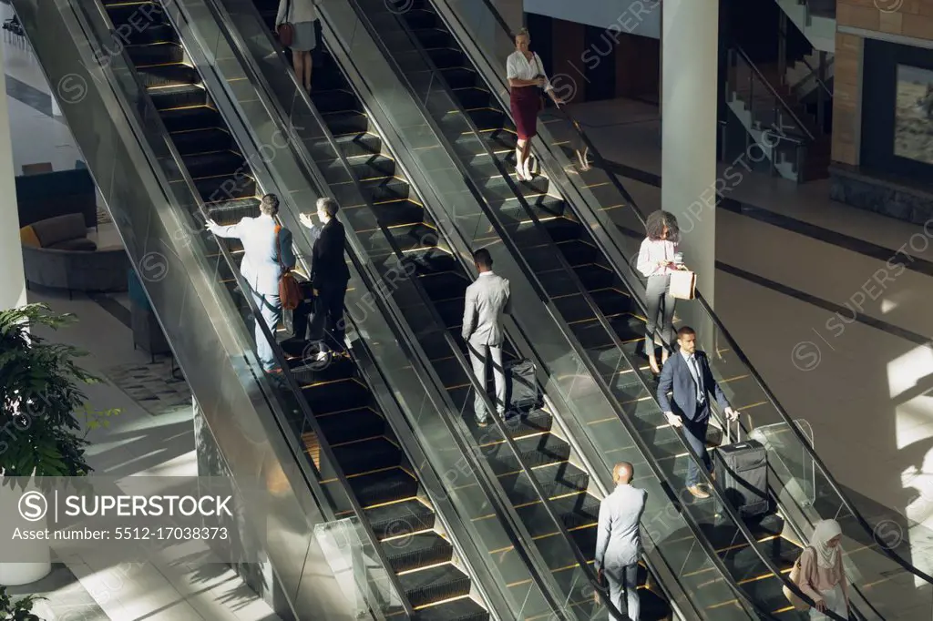 Aerial view of diverse business people using escalators in modern office 