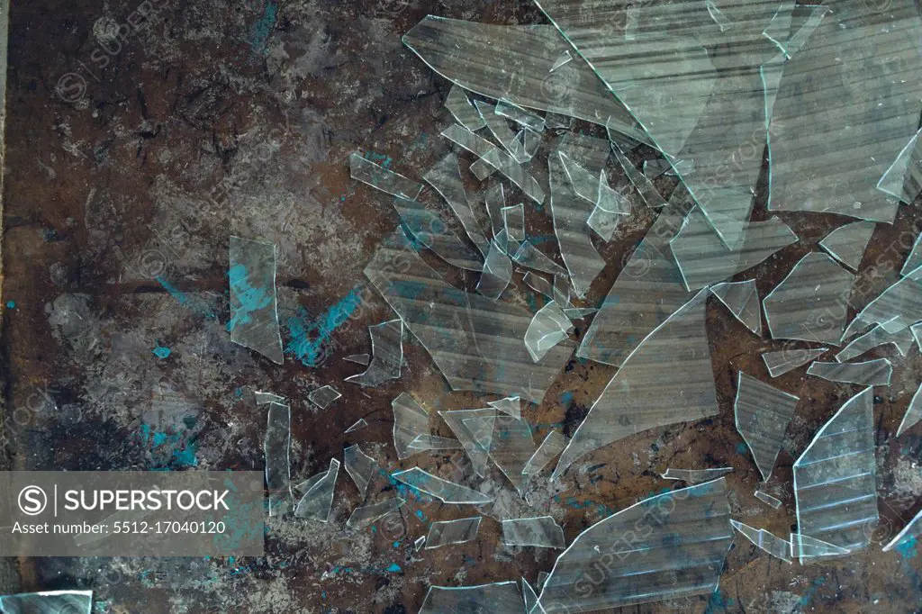 Close up detail of the interior of an abandoned warehouse space showing broken glass