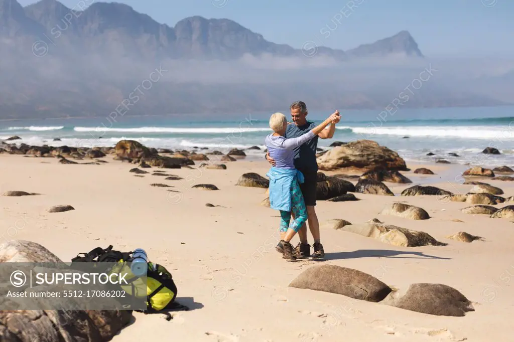 Senior couple spending time in nature together, walking on the beach, dancing. healthy lifestyle retirement activity.