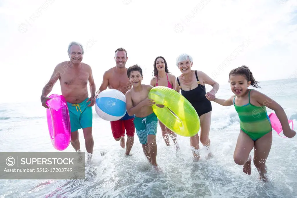 Happy multi-generation family enjoying on sea shore at beach 