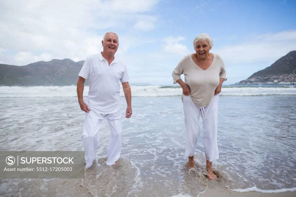 Happy senior couple having fun together at beach