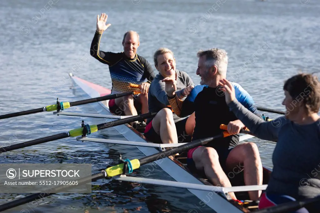 Senior caucasian rowing team having fun while rowing the boat on