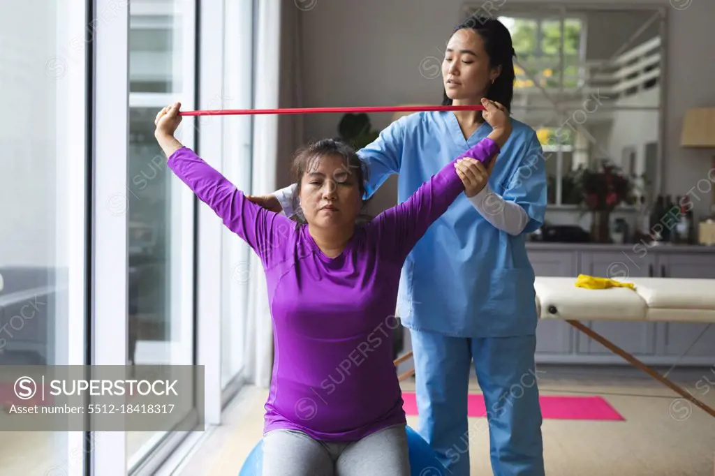 Asian Female Physiotherapist Treating Asian Female Patient At Her Home   5512 18418317.webp