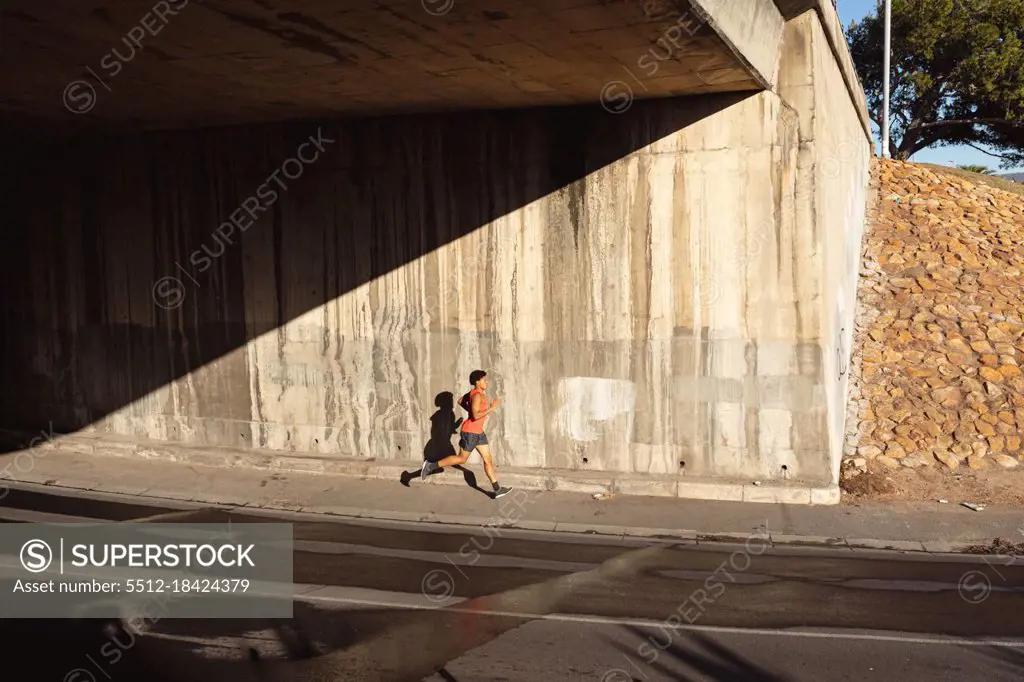 Fit african american man exercising in city running in the street. fitness and active urban outdoor lifestyle.