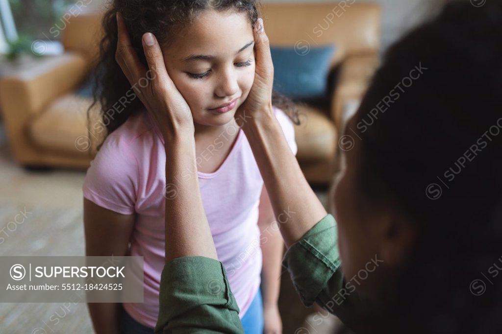 Mixed Race Mother Sitting On Sofa And Touching Her Daughter S Head Domestic Lifestyle And
