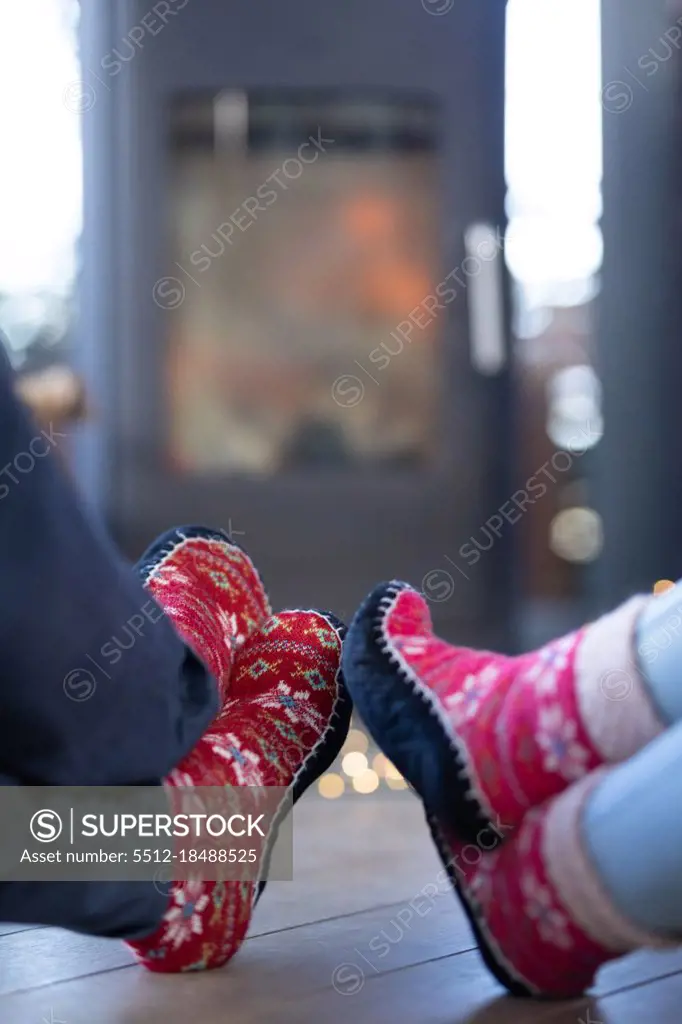 Close up of diverse couple in living room sitting by fireplace. spending time off at home.