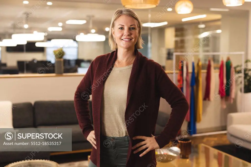 Portrait of smiling caucasian female creative looking to camera. working in creative business at a modern office.