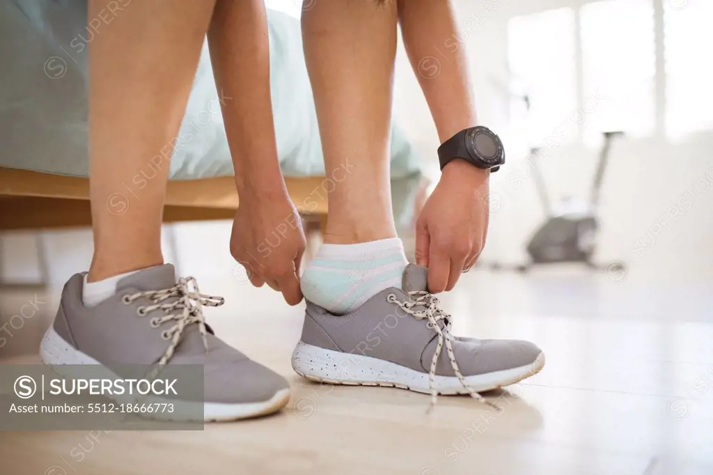 Hands of asian woman preparing for exercise, tying shoes. healthy active lifestyle and fitness at home.