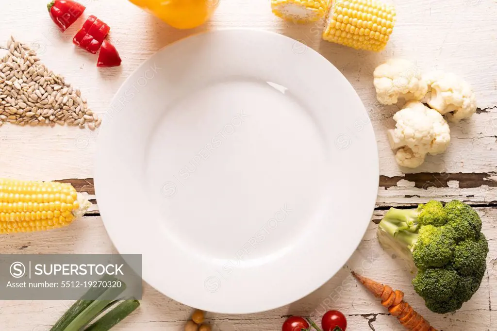 Directly above shot of ingredients arranged around white empty plate on table, copy space. unaltered, food, preparation, healthy eating.