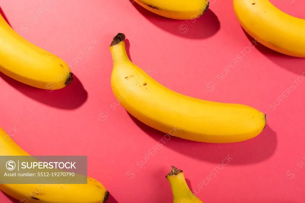 Overhead view of fresh bananas on pink background. unaltered, organic food and healthy eating concept.