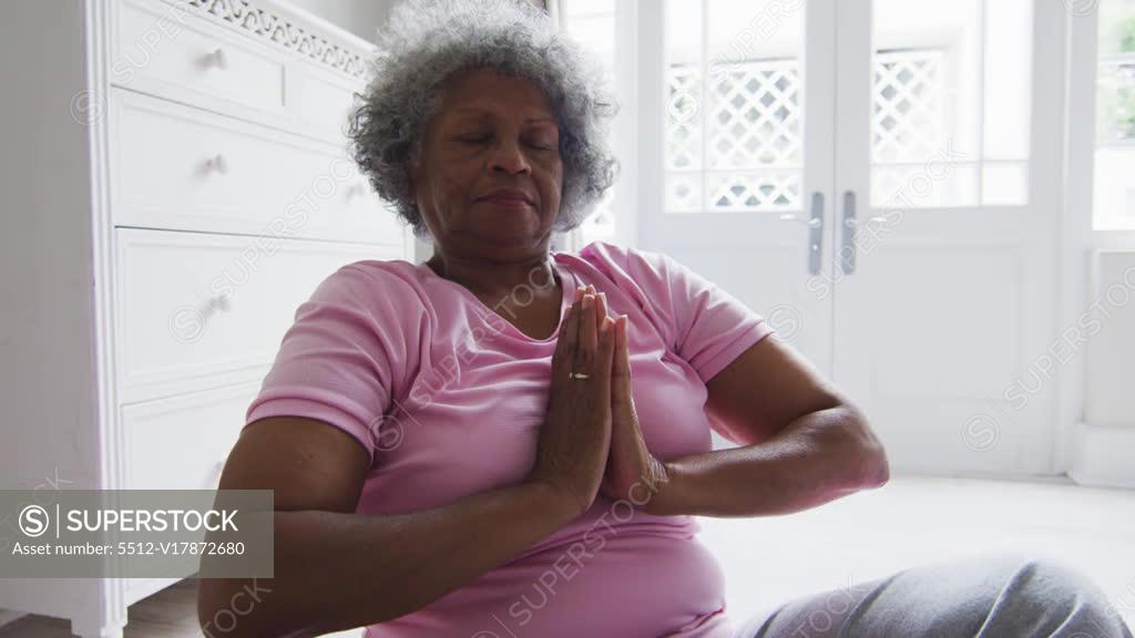 African american mid adult woman practicing yoga during online