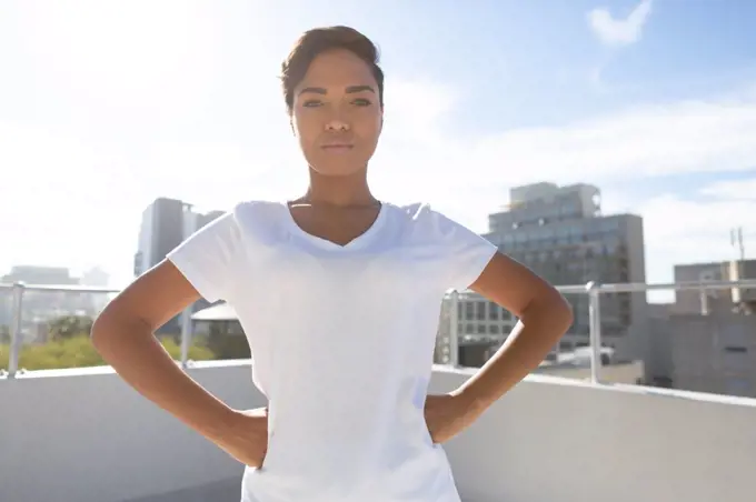 Strong woman standing for breast cancer awareness against a city background